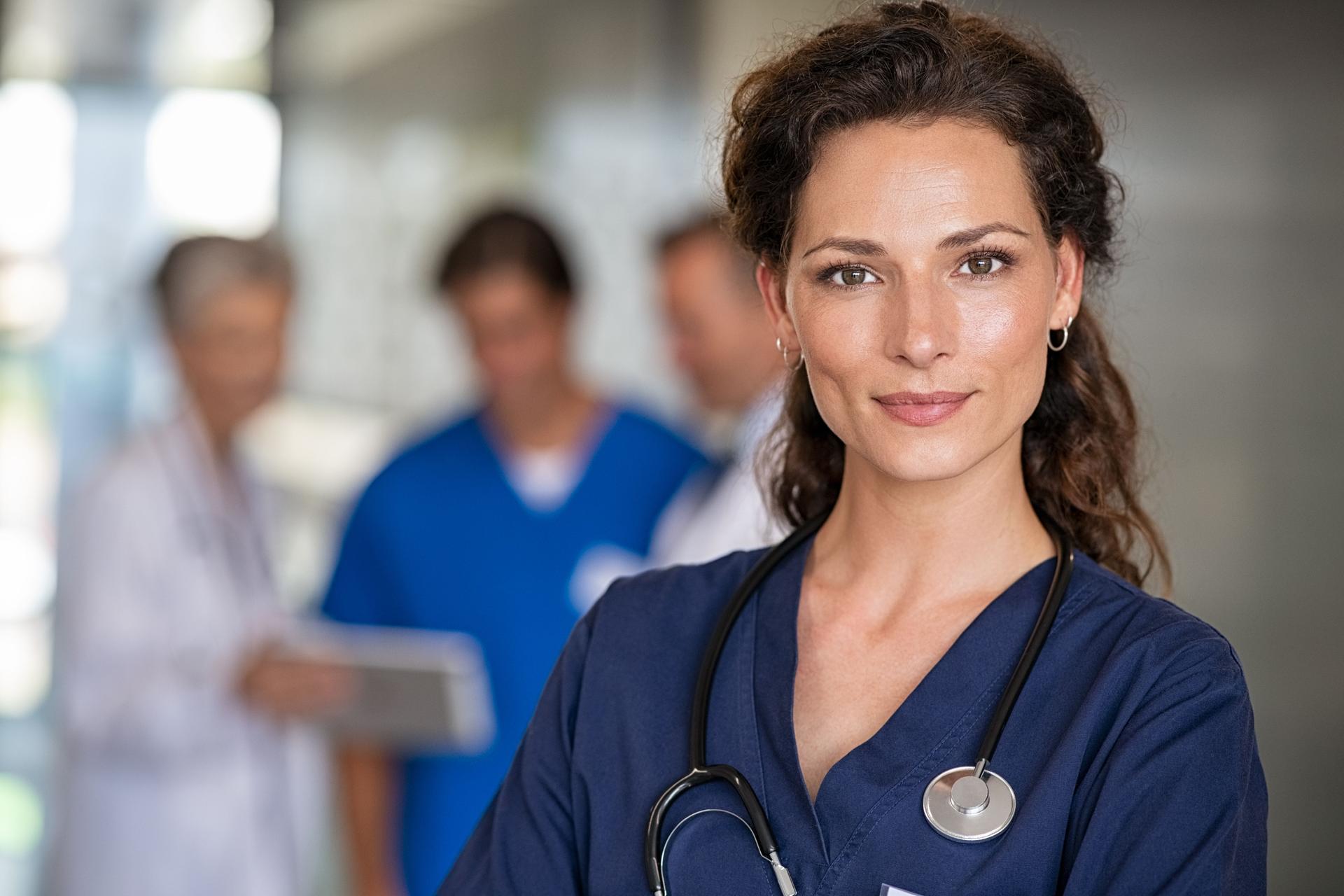 Portrait of successful nurse with team