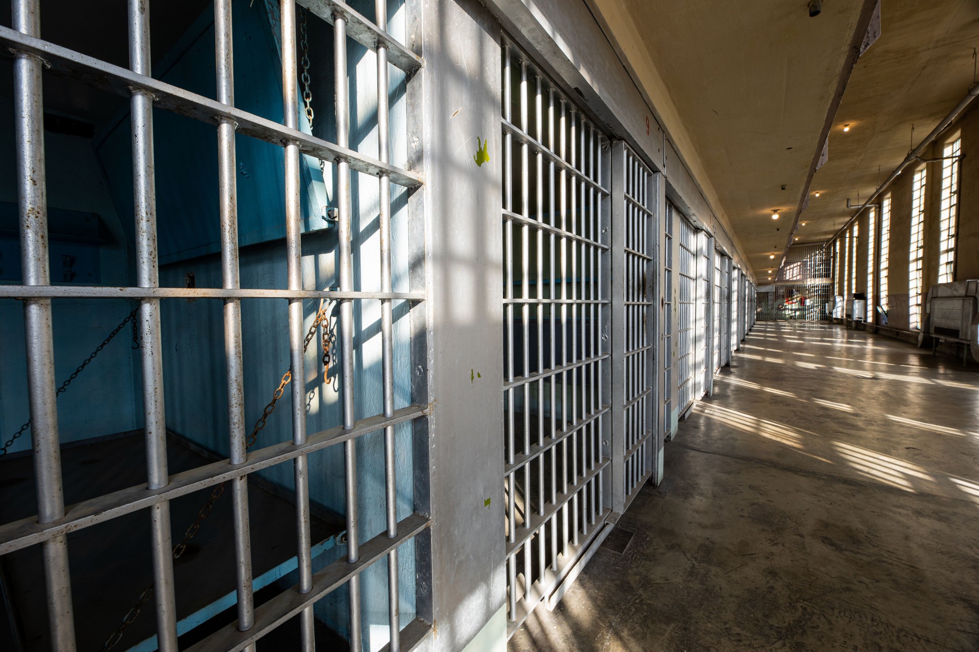sun and shadows form on the bars of a prison